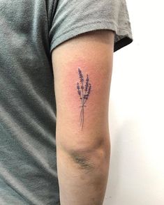 a small lavender tattoo on the left arm