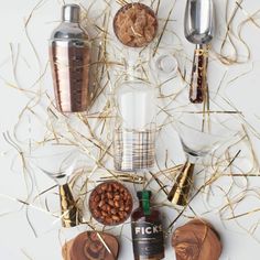 an assortment of food and drink items arranged on a white surface with gold foiling