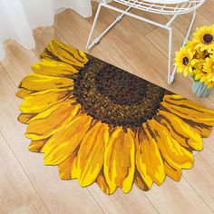 a yellow sunflower rug on the floor next to a pair of slippers