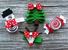 three christmas trees made out of paper and some bows on top of each other, sitting on a wooden surface