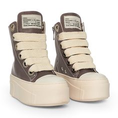 The sneakers are high-top platform-style shoes with a dominant color scheme of chocolate and cream. They feature a thick, cream-colored rubber sole with layered detailing that gives the shoe a bold and chunky silhouette. The upper part of the sneakers is primarily chocolate, constructed with leather material. The design includes metal eyelets for the laces, which are cream-colored and chunky, complementing the sole. Christian Zerotre, Chocolate Sneakers, Chunky Tennis Shoes, Doctor Shoes, Chunky Platform Shoes, Curvy Casual Outfits, Creative Shoes, Pretty Shoes Sneakers, Shoes Outfit Fashion