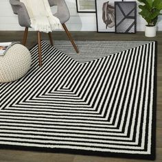 a black and white area rug in a room with pictures on the wall behind it