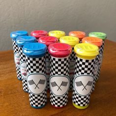 six cups with different designs on them sitting on a wooden table next to each other