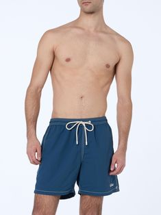 Introducing our Patmos swim shorts, crafted from textured polyester fabric, offering a cotton-like touch. Enhanced with contrast stitching and drawstring, as well as the embroidered exclusive Saint Barth logo detail at the bottom leg. Features a back pocket with flap and velcro closure. This version is made from fast-drying seersucker fabric with a vertical pinstripe pattern. Man Patmos mid-length swim shortsFast dry seersucker fabricSky blue plain colorExclusive Saint Barth logo detail at the bottom legComfortable elasticized waistbandAdjustable drawcord with branded terminalsInner mesh liningSide pockets with French seamsBack patch pocket with velcro closureBranded eyelets designed to drain water and prevent ballooning effectMC2 Saint Barth exclusive label on the backClassic fitCompositi Summer Bottoms With Contrast Stitching In Short Length, Summer Bottoms With Contrast Stitching And Short Length, Summer Shorts With Contrast Stitching, Navy Drawstring Bottoms For Beach, Blue Cotton Swim Trunks With Drawstring, Navy Nylon Beach Bottoms, Navy Nylon Beachwear Bottoms, Blue Cotton Swimwear With Drawstring, Blue Shorts With Functional Drawstring