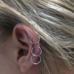 a close up of a person's ear with two rings attached to the back of it