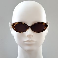 Round Cateye sunglasses.  Tortoiseshell acetate frame with black lenses.  Frame Specs: Lens Category 3 UV400 100% UV Protection Acetate Frame Lens Height: 32mm, Lens Width: 50mm, Sunglass Length (including frame): 143mm Classic Cat Eye Sunglasses For Summer, Classic Cat Eye Sunglasses For Beach, Classic Acetate Cat Eye Sunglasses For Summer, Modern Tortoiseshell Sunglasses For Summer, Retro Sunglasses With Tinted Lenses, Classic Summer Cat Eye Sunglasses In Acetate, Trendy Tortoiseshell Cat Eye Sunglasses With Uva Protection, Casual Tortoiseshell Cat Eye Sunglasses With Gradient Lenses, Trendy Brown Acetate Cat Eye Sunglasses