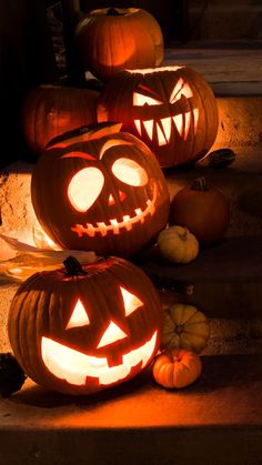 three carved pumpkins sitting on the steps