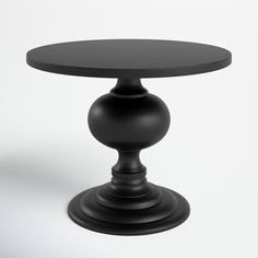 a black round table sitting on top of a white floor