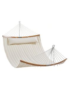 a large white hammock hanging from the side with two pillows on top of it