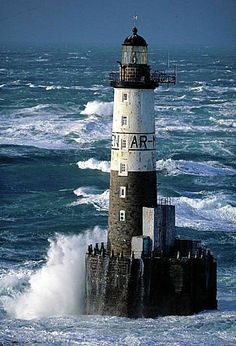 the lighthouse is surrounded by rough waves in the ocean