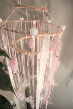 a pink and white dream catcher hanging from the ceiling