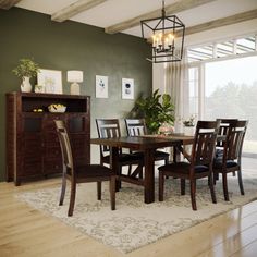 a dining room table and chairs in front of a large window with an open bookcase