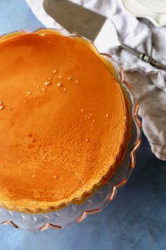 a cake sitting on top of a glass plate next to a knife and napkins