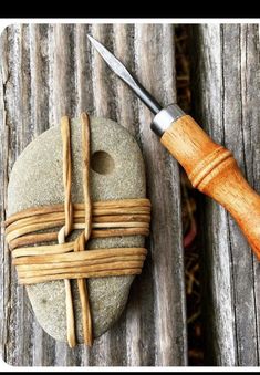 a rock with a cross on it and a sharp knife next to it that has been made out of some kind of wood