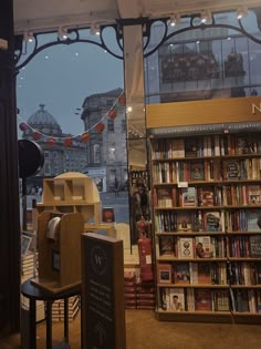 a book store with lots of books on display in front of the window and an open door