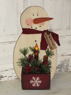 a wooden snowman with a red scarf and hat