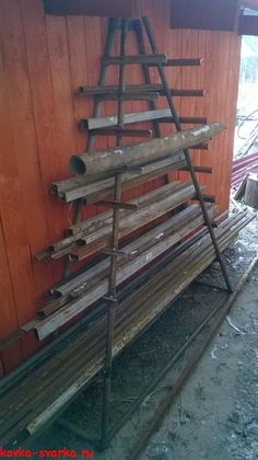 a pile of wood sitting on top of a wooden floor next to a red building