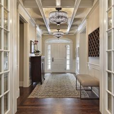 an entry way with a chandelier hanging from the ceiling