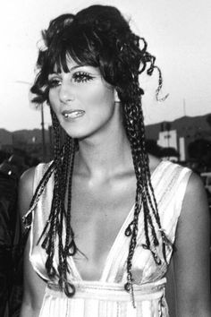 a black and white photo of a woman with braids on her hair wearing a dress