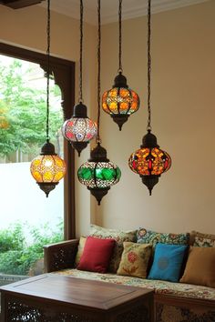 a living room filled with lots of different colored lights hanging from the ceiling over a couch