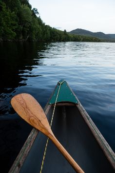 a wooden paddle sitting on top of a boat in the middle of a body of water