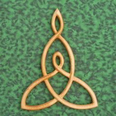 a wooden ornament with two interlocked circles on a green tablecloth