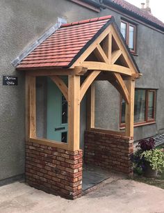 a wooden gazebo sitting in front of a house