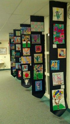 the hallway is decorated with colorful art and pictures on black paper, along with blue carpeting