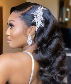 a woman with long black hair wearing a white dress and some flowers in her hair