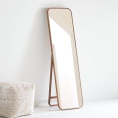 a mirror sitting on top of a white floor next to a stool