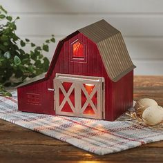 a small red barn with eggs on a table