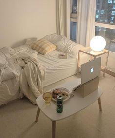 a bed room with a laptop and a table