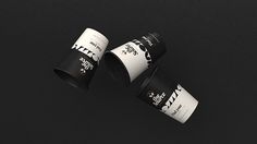 three black and white coffee cups sitting on top of each other in front of a black background