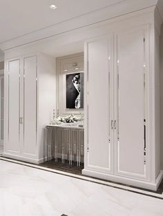 a large white closet with many doors and drawers on the wall next to a table