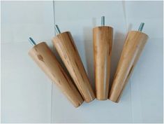 four wooden dowels with metal tops on a white surface, one has two screwdrivers in it