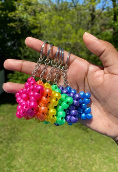 a hand holding a bunch of multi colored beads