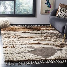 a living room with a large rug on the floor next to a chair and window