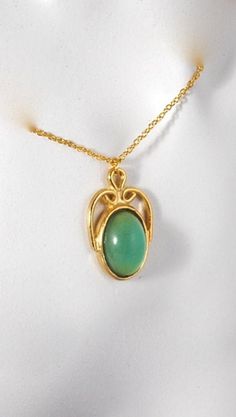 "This vintage piece is just so pretty! The green cabochon looks almost transparent against the gold tone. Hangs from a vintage 16\" chain and measures approximately 1 1/8\" in height and 3/4\" wide." Gold Hallmarked Oval Cabochon Necklaces, Green Cabochon Oval Pendant Necklace, Oval Cabochon Costume Jewelry Necklace, Oval Cabochon Brass Necklace, Gold Chrysoprase Pendant Necklace, Vintage Yellow Gold Cabochon Necklace, Vintage Hallmarked Oval Cabochon Necklace, Vintage Green Oval Cabochon Jewelry, Antique Green Oval Pendant Necklace