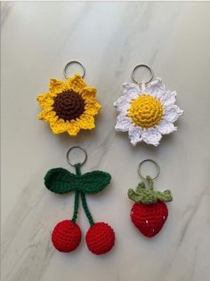 four crocheted key chains with flowers and cherries