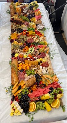 a long table filled with lots of different types of food on top of white cloth