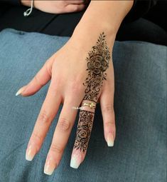 a woman's hand with a henna tattoo on it