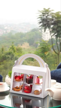 a tea set on a table in front of a window