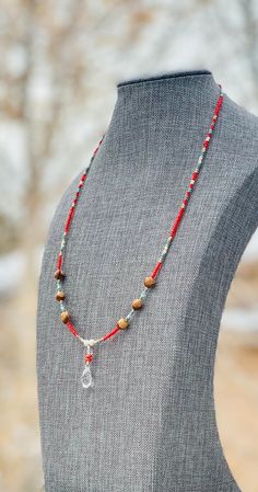 Authentic Native American, handmade, Cedar Juniper Berry seed and Crystal pendant necklace. Cedar beads, colorful glass seed beads, round silver beads and a charm are strung with jewelry wire and closed with lobster claw clasp. Navajo legend says Cedar beads, also known as "Ghost Beads," will keep evil spirits and bad dreams away.  For example, it is customary for Navajo mothers to place strung cedar beads on/near their traditional cradle boards used by their infants.  By season, Navajo and Ute Indians harvest cedar seeds in the southwestern U.S.A. which is a long and arduous process.  The season's yield depends on the amount of rainfall received during the year.  The Indians carefully select the seeds which have had their core previously eaten by ants which is evidenced by a single hole i Red Bohemian Necklace With Heishi Beads, Southwestern Beaded Necklaces As Gift, Southwestern Necklace With Dangling Beads, Southwestern Beaded Necklaces For Gift, Southwestern Style Beaded Necklaces For Gifts, Southwestern Style Necklace With 108 Beads As Gift, Southwestern Style Necklace With 108 Beads For Gifts, Silver Heishi Beads Bohemian Necklace, Silver Bohemian Heishi Beaded Necklaces