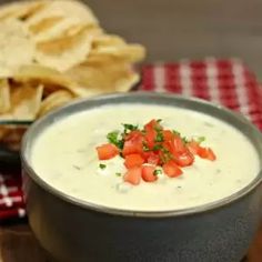 a bowl of dip with chips on the side