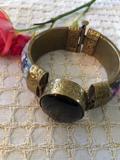 "Lovely vintage Cloisonné hinged brass bracket. Pink and blue floral designs. Large black celluloid stone embellishment. Decorative hinged closure. Very pretty. This bracelet was given to me by my sister who wore it in the 70s then stored it for years. It is in great vintage condition. Diameter is 2.5\", width is 0.5\". Remember: Vintage is never perfect. Each vintage item was owned and used for years before it was found and listed in this shop. Please see all photos as they are part of the desc Vintage Adjustable Brass Bangle, Adjustable Vintage Brass Bangle, Vintage Adjustable Hinged Bracelet, Vintage Adjustable Hinged Cuff Bracelet, Vintage Adjustable Bracelets With Box Clasp, Vintage Adjustable Hinged Bracelets, Vintage Adjustable Hinged Bangle, Adjustable Vintage Bracelets With Box Clasp, Vintage Metal Hinged Cuff Bracelet