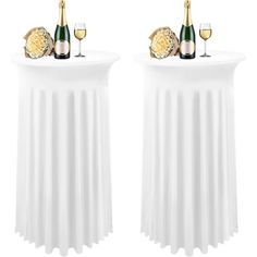 two white tables with wine glasses and bottles on them