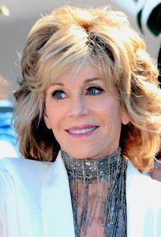 a woman with blonde hair wearing a white jacket