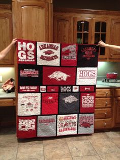 two people are holding up a quilt made to look like the college football team's logos