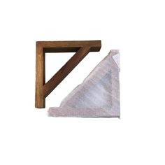 a triangle shaped object sitting on top of a white towel next to a wooden frame