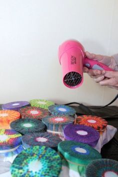 a person using a hair dryer on some cupcakes